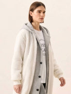 Woman wearing white oversized sherpa long coat with cozy lining and casual outfit underneath, everyday wear oversized coat style