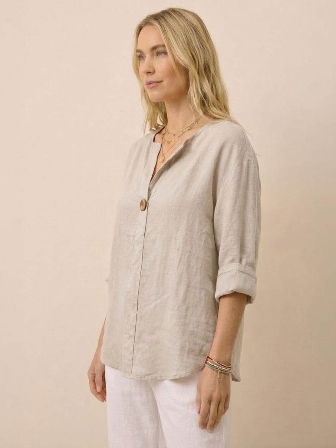 Woman wearing beige pure linen age-defying shirt with button detail and rolled sleeves