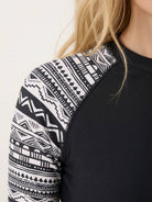 Woman wearing swim shorts rash guard set with long raglan sleeves and matching boyshort bottoms on beach