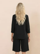 Woman wearing a polished blazer and high-waisted shorts two-piece set in a monochrome style