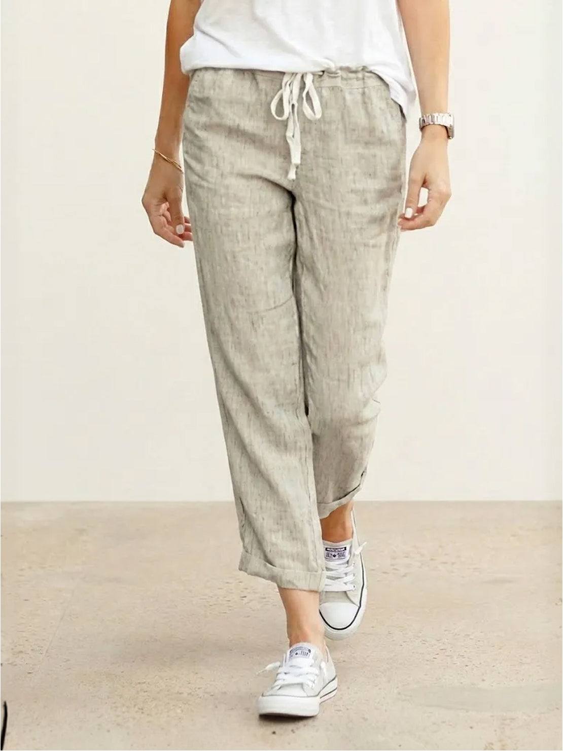 woman wearing orange relaxed fit straight pants with hands in pockets standing outdoors