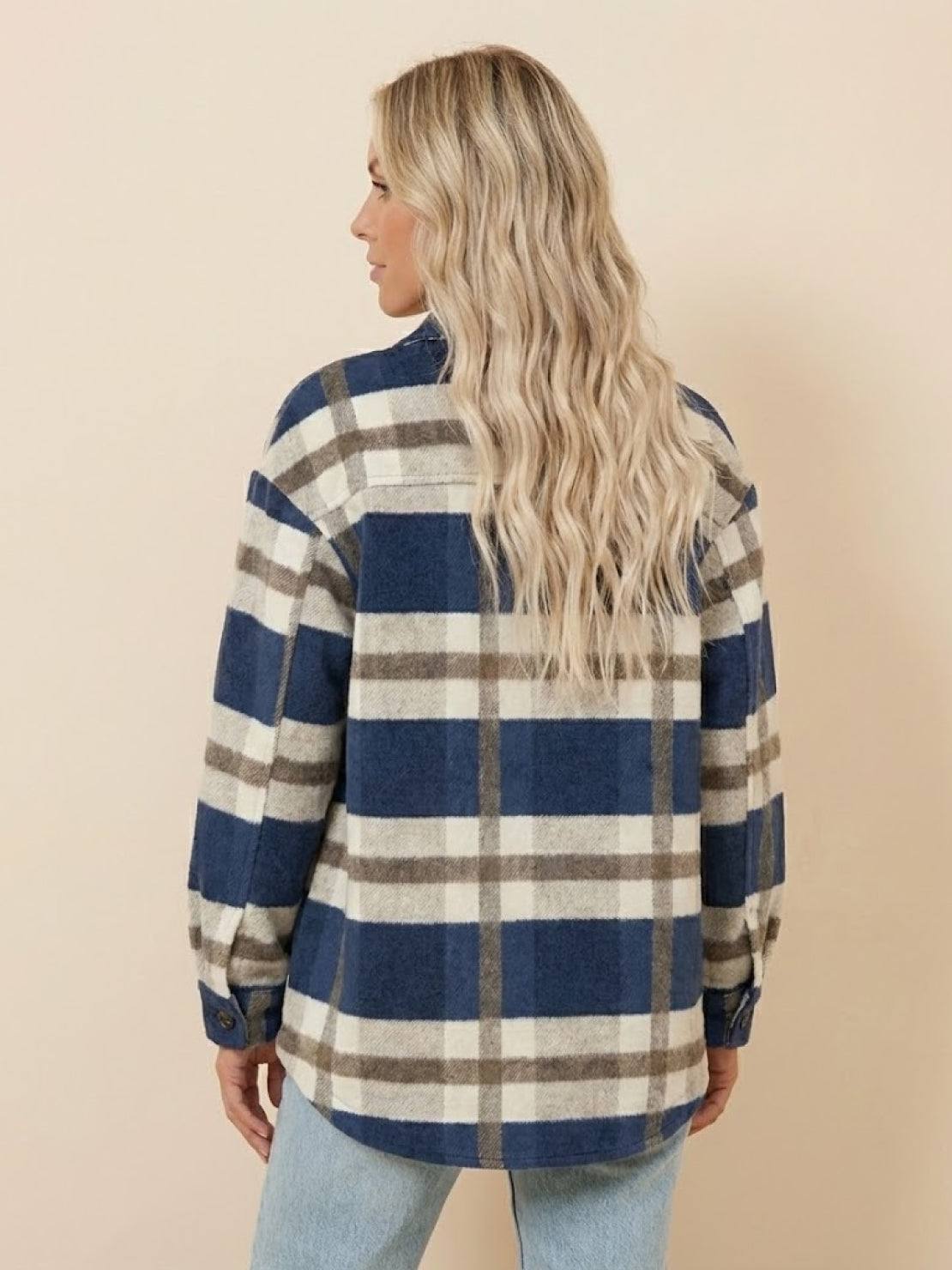 Woman wearing a blue and beige plaid comfy flannel classic button-down shirt seen from the back