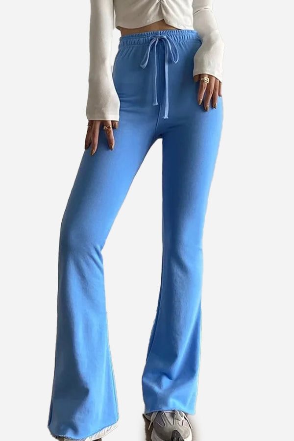 Blue comfy wide-leg pants with elastic waistband and drawstring, styled with a white cropped top and sneakers.