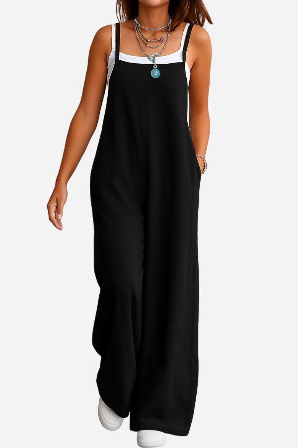 Woman wearing black cotton blend comfort jumpsuit with wide-leg design and layered necklaces on white background