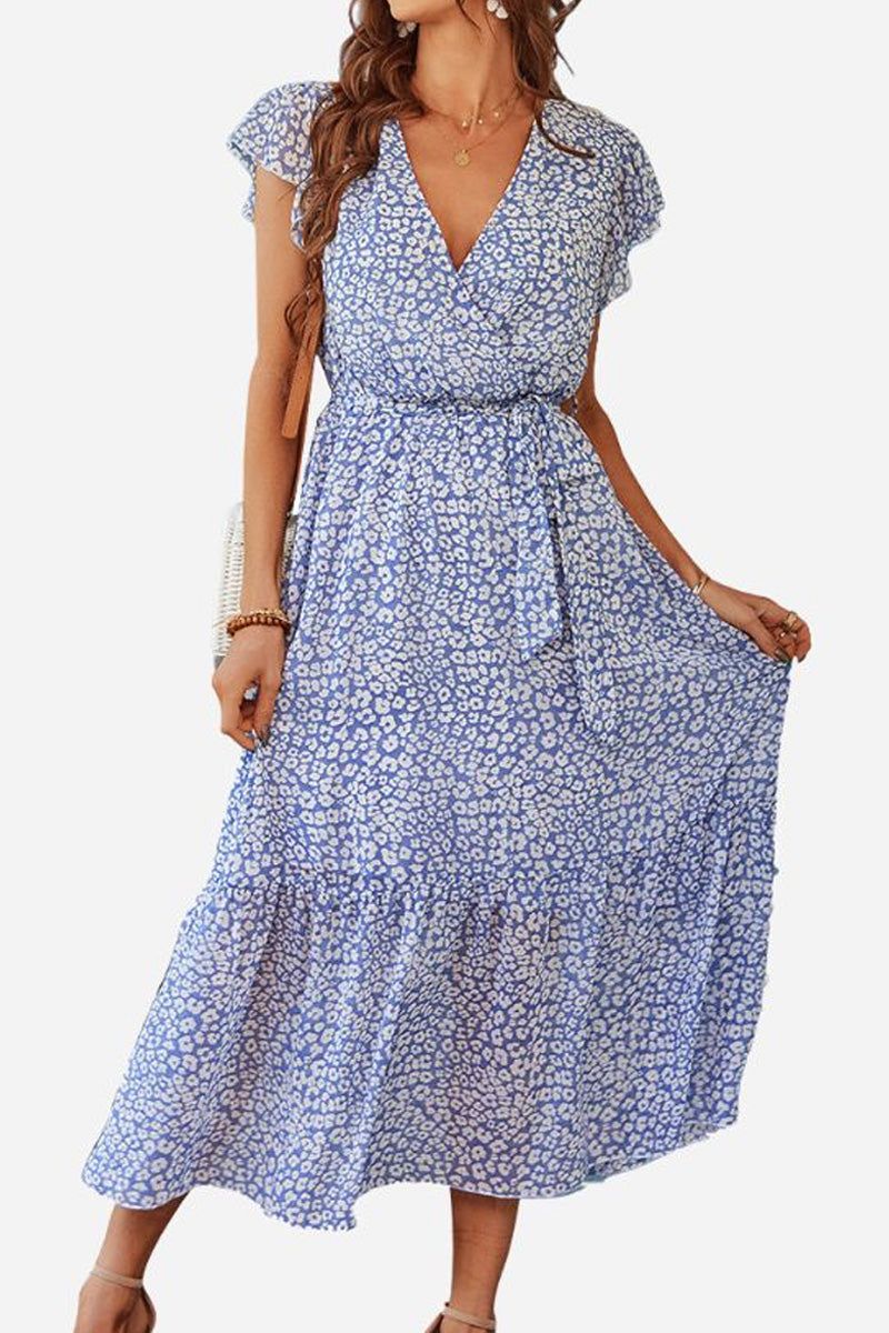 Woman wearing Elegant Blossoms Boho Maxi Dress with blue floral pattern, V-neck, short sleeves, and belted ruffle hem.