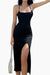 Woman wearing a black elegant side slit midi dress with thin straps and a high slit on one side holding a white handbag