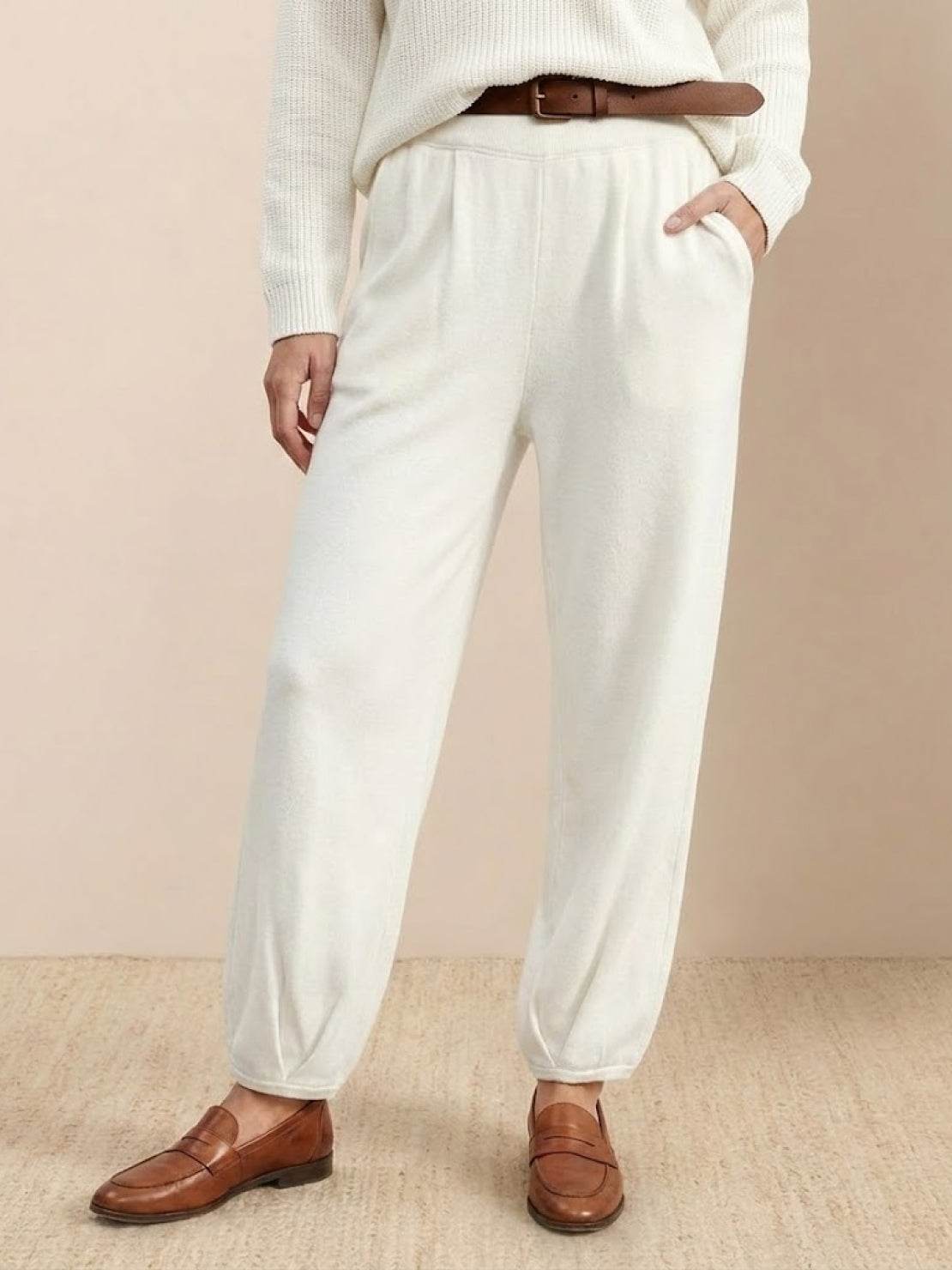 White relaxed knit trousers styled in European Minimalism fashion with casual loafers and belt