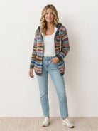 Woman wearing Highland Plaid Shacket layered over jeans with a relaxed hooded fit and button-front closure