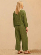 woman wearing loose solid color olive green two-piece set back view