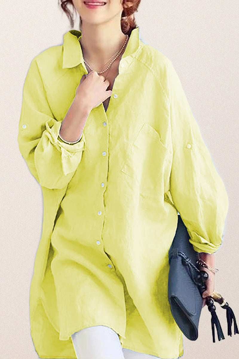 Oversized linen shirt in soft yellow with relaxed fit and button-down front, styled with white pants and navy handbag.