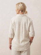 Back view of woman wearing oversized 100% cotton shirt and wide-leg pants co-ord set in beige