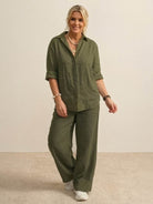 Woman wearing oversized 100% cotton olive green shirt and wide-leg pants co-ord set with rolled sleeves and relaxed fit