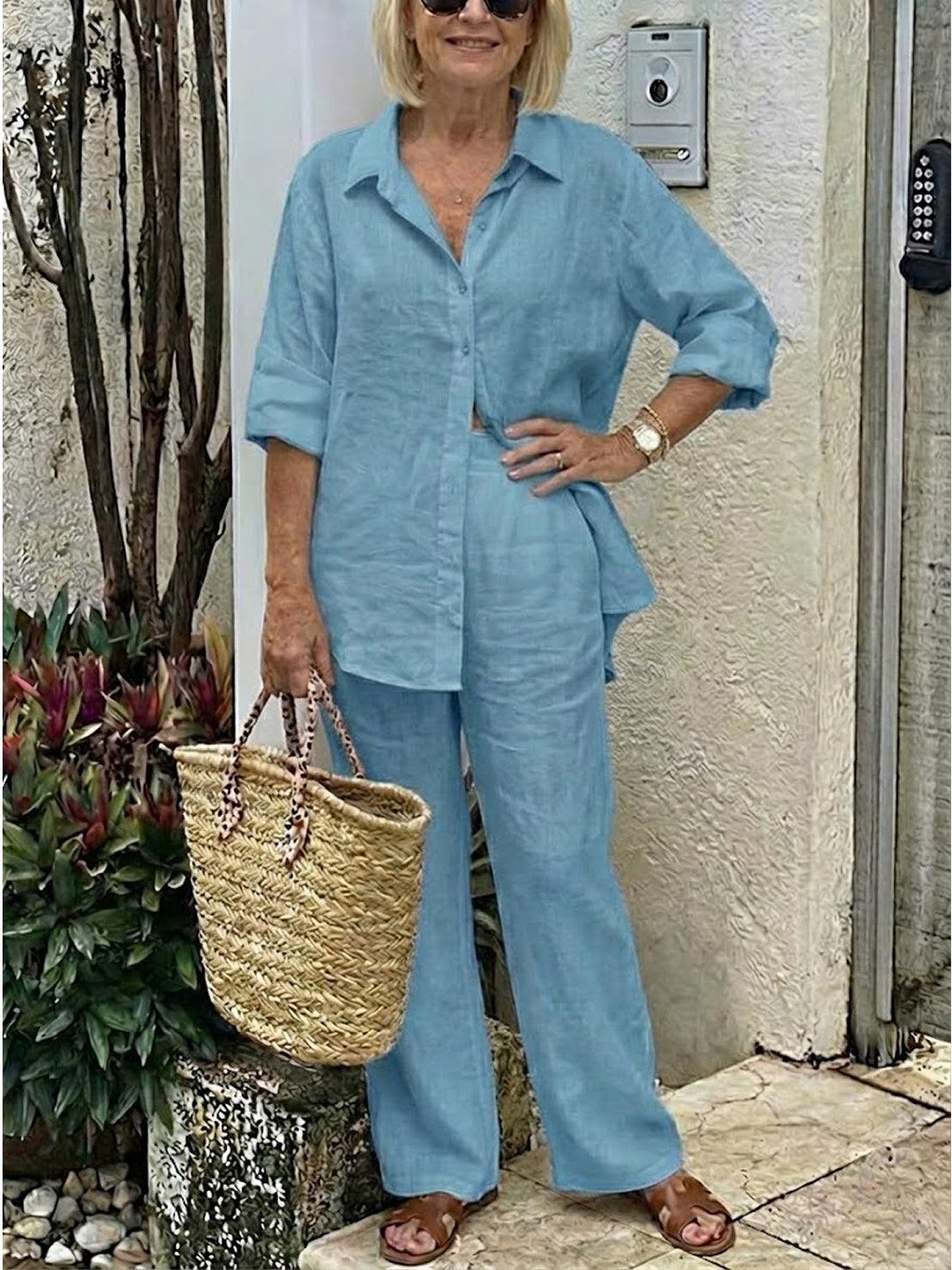 Woman wearing oversized 100 cotton shirt and wide-leg pants co-ord set in blue with rolled sleeves and straw tote bag