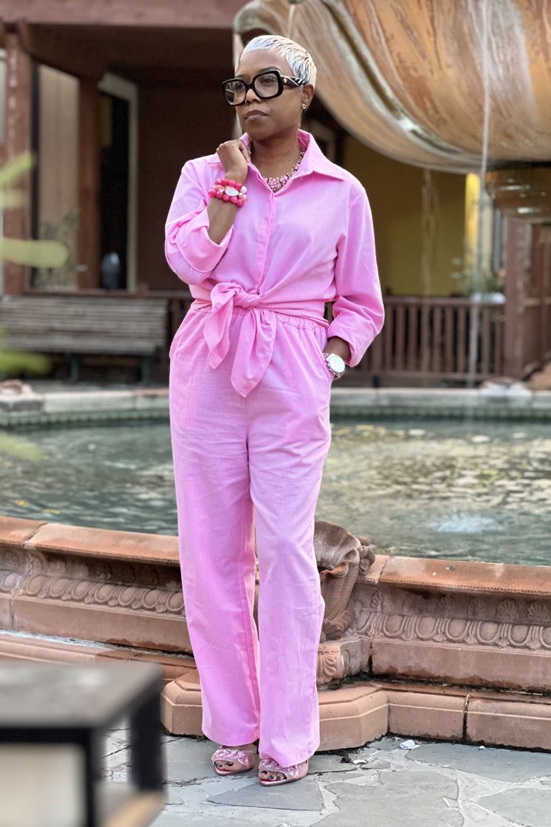 Woman wearing oversized 100% cotton pink shirt and wide-leg pants co-ord set outdoors near fountain