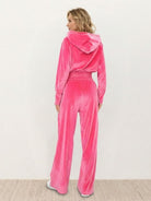 Model wearing modern cropped velour tracksuit set with high-waist pants in vibrant color