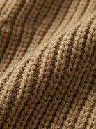 Close-up texture of relaxed fit oversized knitwear cardigan fabric in warm brown color