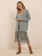 relaxed fit oversized button down knitwear cardigan in light grey worn with floral midi skirt and brown ankle boots