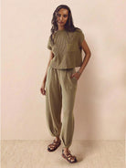 Woman wearing comfy couture knit sweater two-piece set in neutral tone, featuring relaxed fit sweater and matching pants for casual stylish wear