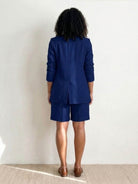 Woman wearing stylish blazer and shorts two-piece set in vibrant peach color