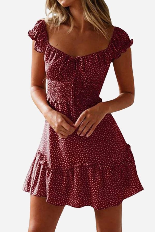 Woman wearing a red sweetheart collar printed ruffled mini dress with short sleeves and a high waist design.