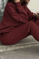 Burgundy cotton blend tracksuit with relaxed fit and minimal design, featuring stretch waistband and cuffs for tailored comfort.