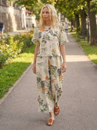 Woman walking outdoors wearing floral loose fit co-ord set with wide-leg trousers and short-sleeve top
