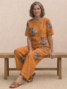 Women wearing a loose fit co-ord set with a soft-tailored top and wide-leg bottoms in neutral solid colors.