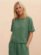 Woman wearing green loose fit co-ord set with relaxed short-sleeve top and wide-leg pants