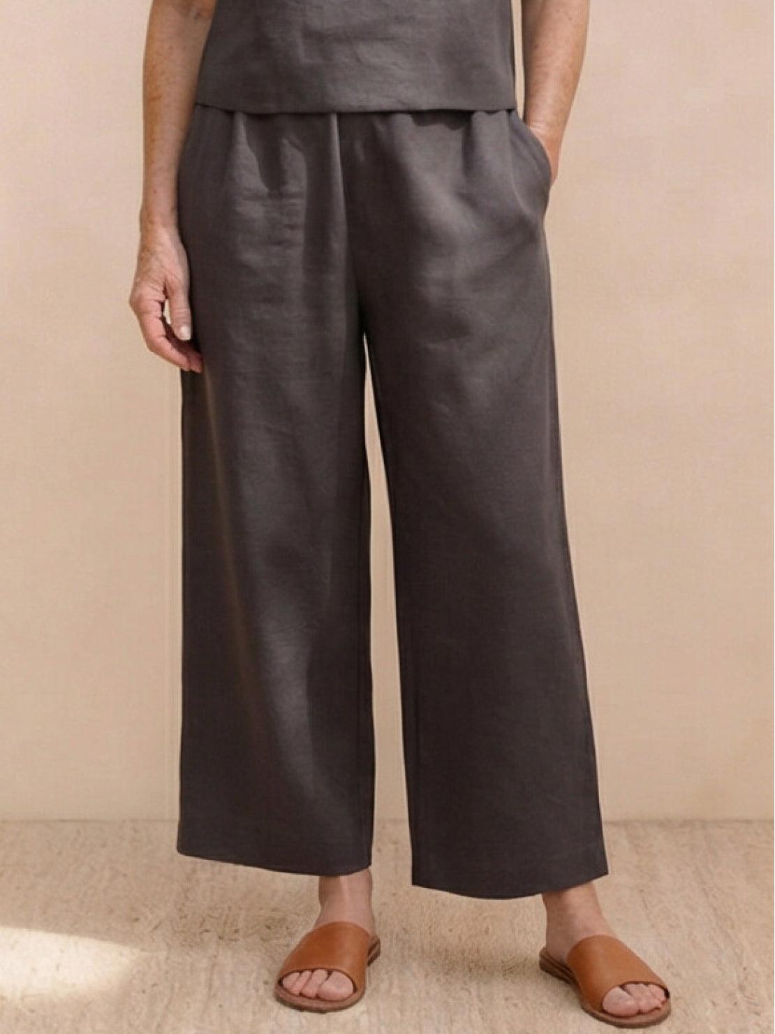 Woman wearing a relaxed loose fit co-ord set with soft-tailored top and wide-leg bottoms in neutral solid color