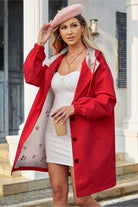 Woman wearing red Rain Couture Windbreaker with floral lining and beret holding coffee cup outdoors