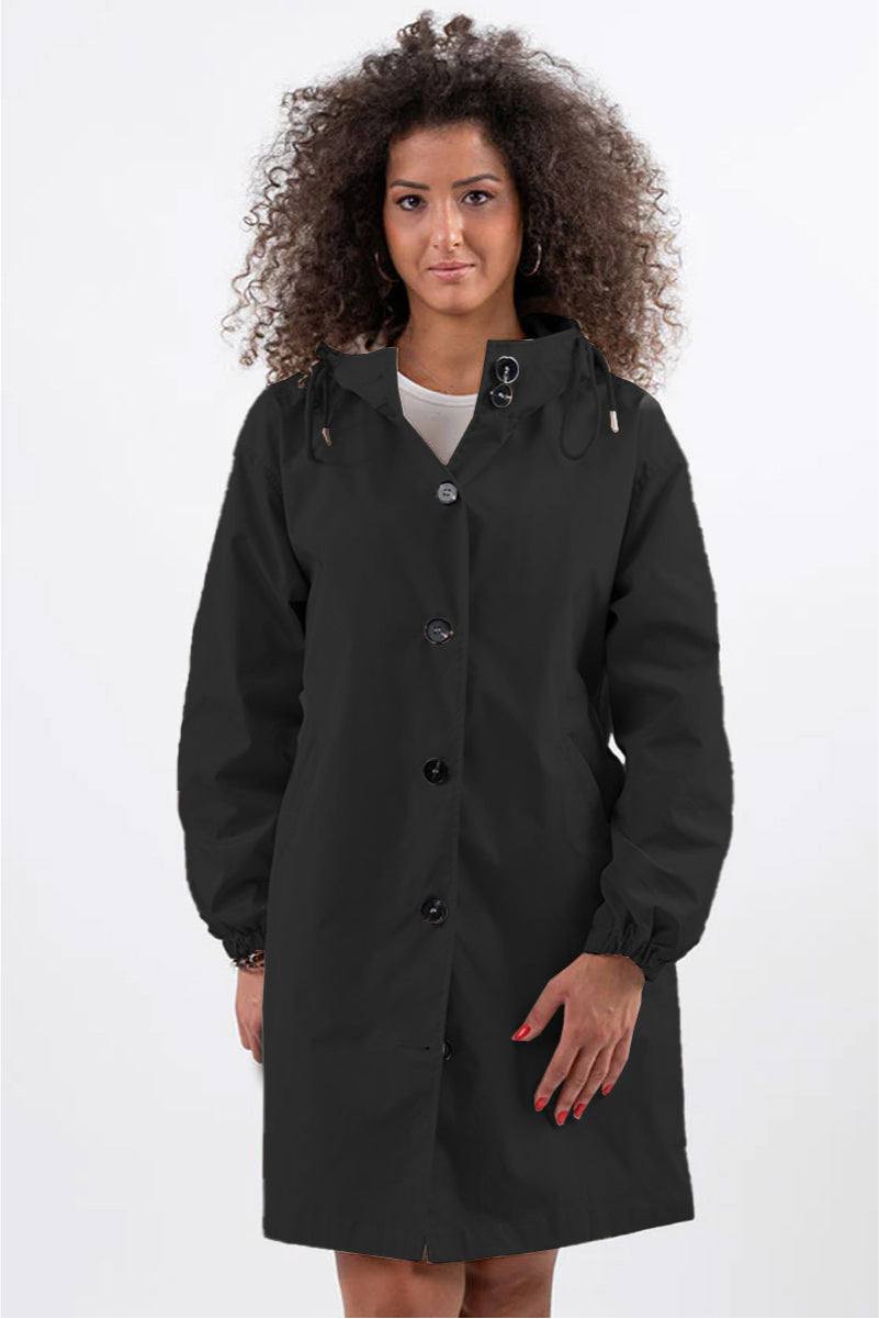 Woman wearing black oversized Rain Couture Windbreaker water-resistant jacket with hood and buttons