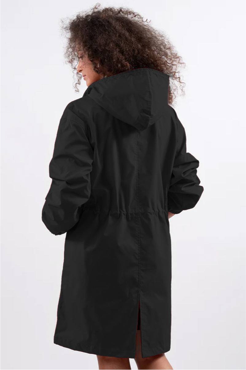 Back view of woman wearing black oversized water-resistant Rain Couture Windbreaker with hood