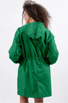 Woman wearing green oversized Rain Couture Windbreaker jacket with hood, back view