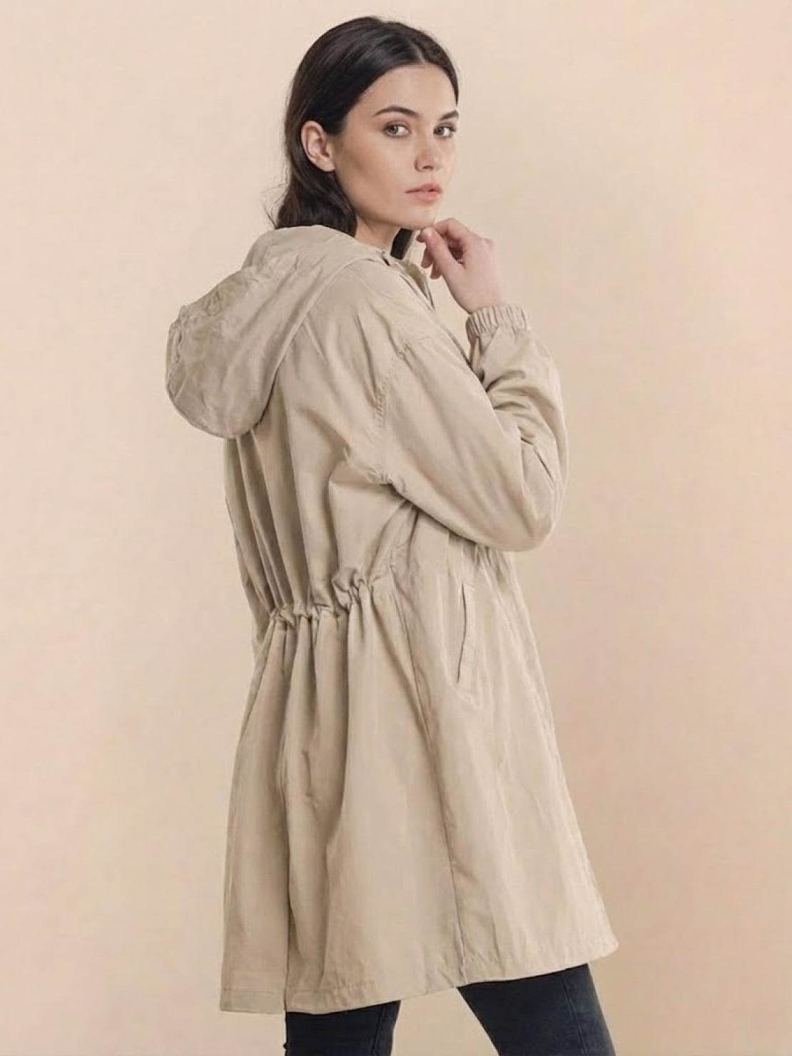 Woman wearing beige oversized Rain Couture Windbreaker with hood and adjustable waist