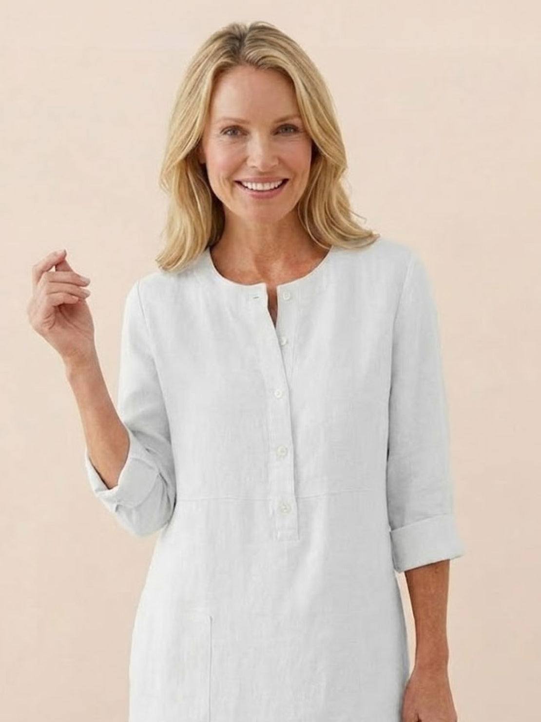 Woman wearing a white timeless class cotton dress with 3/4 rolled sleeves and button front detail