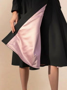 Water-repellent A-line hooded raincoat with belt for women, elegant and insulated weather-resistant outerwear.