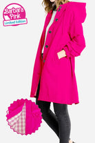 Woman wearing Barbara Pink Raincoat Windbreaker jacket in vibrant pink with hood and button details, showing lightweight water-resistant fabric and checked lining.