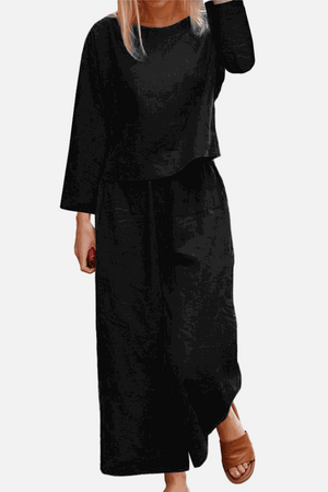 Woman wearing a loose solid color black two-piece set with long sleeves and wide-leg pants